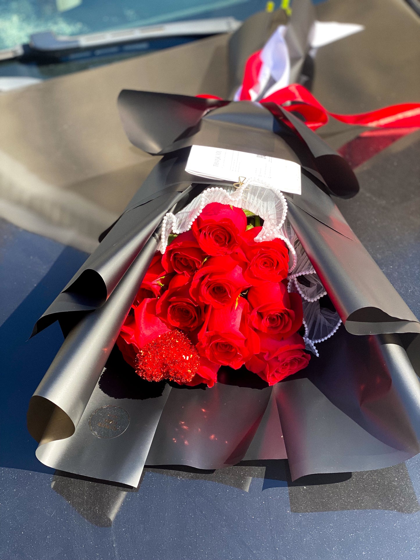 Dozen Red Premium LONG STEM Roses covered in colored waterproof paper (on the picture 25 roses )