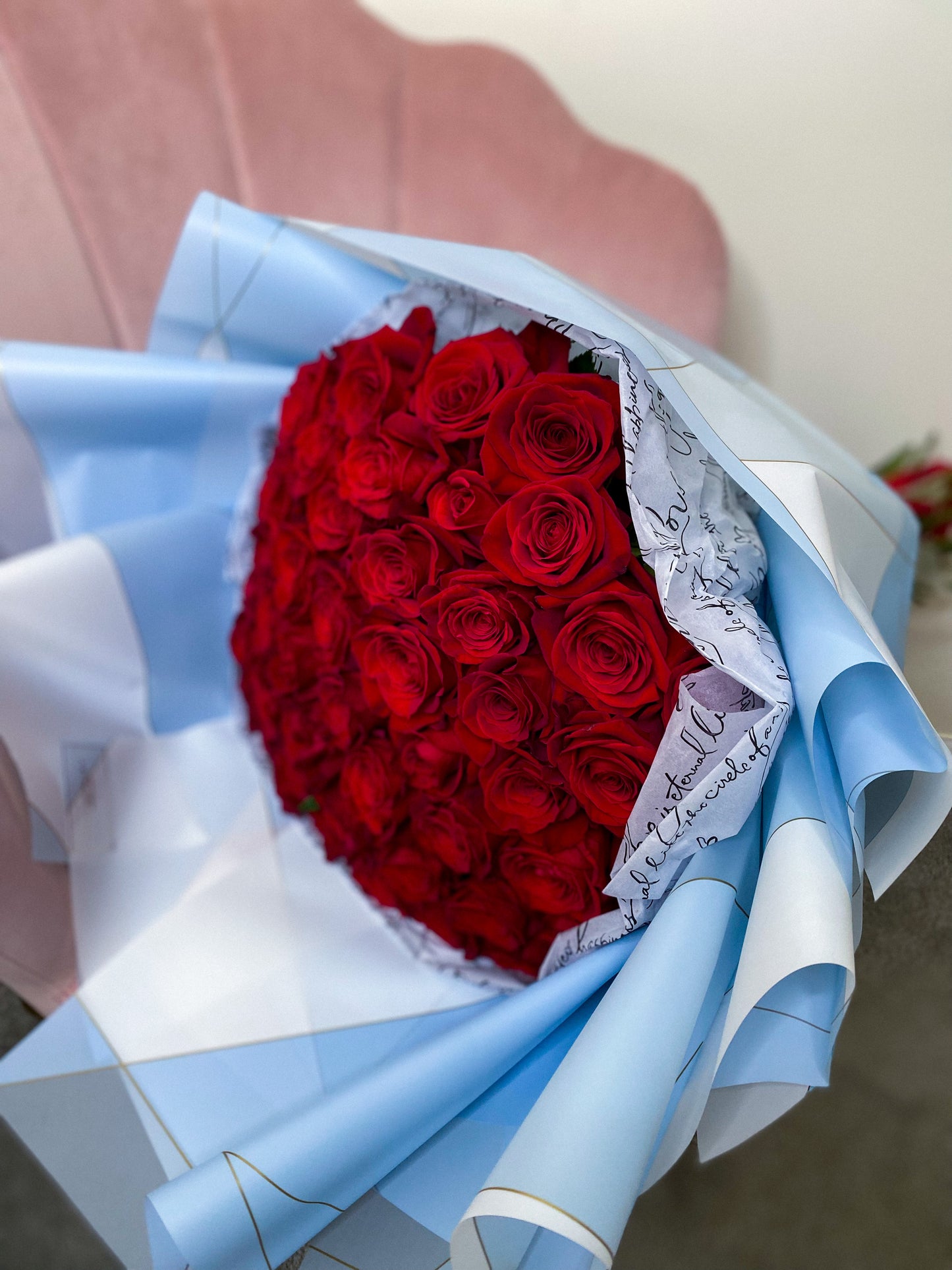 50 red roses in blue wrapping paper